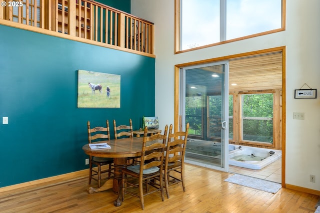 dining room with a high ceiling and light hardwood / wood-style flooring