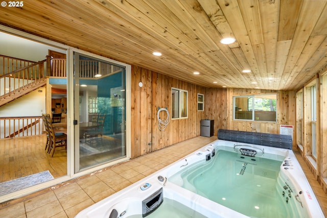 interior space with wooden ceiling, a washtub, tile patterned floors, and wood walls