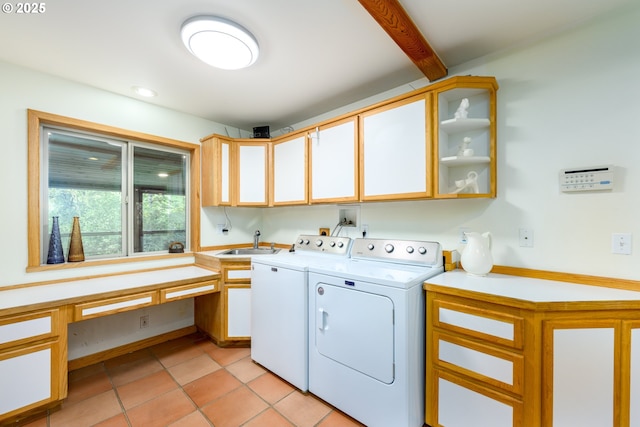 laundry room with cabinets, sink, light tile patterned floors, and washing machine and clothes dryer