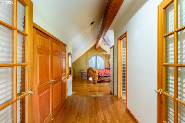 hall featuring vaulted ceiling with beams and light wood-type flooring