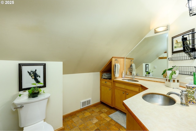 bathroom featuring lofted ceiling, vanity, and toilet