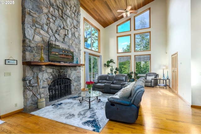 living room featuring a fireplace, lofted ceiling, ceiling fan, wood ceiling, and light wood-type flooring