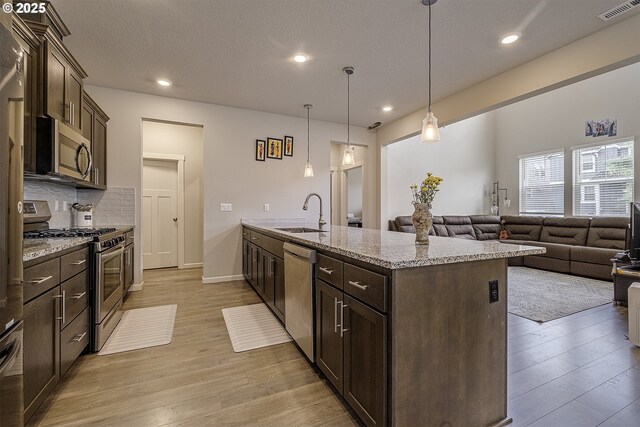 30942 NW Turel Dr, North Plains, OR 97133 - kitchen featuring stainless steel appliances, dark brown cabinetry, light wood-style floors, a sink, and recessed lighting