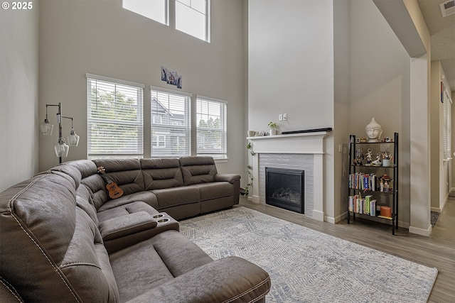 30942 NW Turel Dr, North Plains, OR 97133 - living area featuring a fireplace, a high ceiling, healthy amount of natural light, and wood finished floors