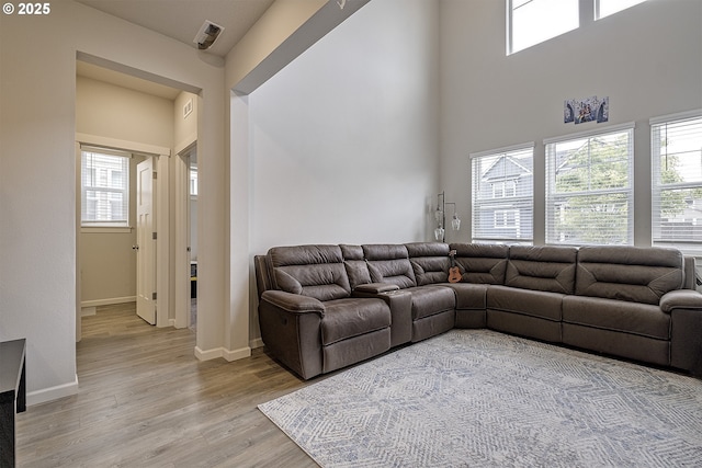 30942 NW Turel Dr, North Plains, OR 97133 - living room featuring light wood finished floors, healthy amount of natural light, baseboards, and a towering ceiling
