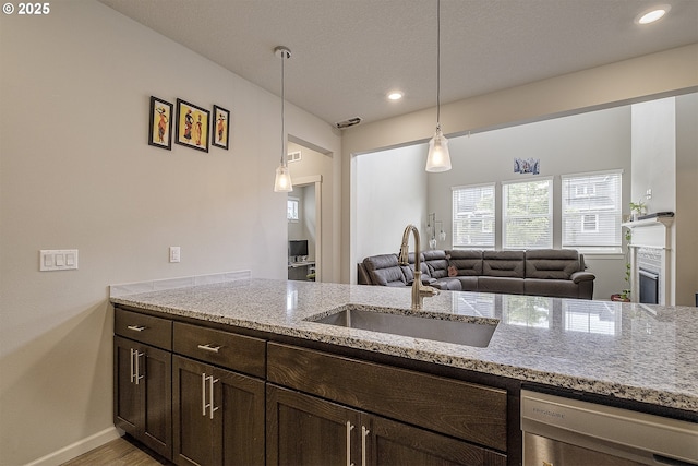 30942 NW Turel Dr, North Plains, OR 97133 - kitchen featuring a sink, dark brown cabinets, light stone counters, decorative light fixtures, and recessed lighting