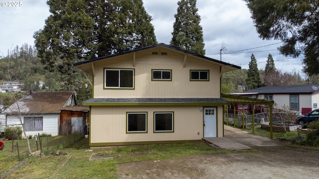 back of house featuring a shingled roof and fence