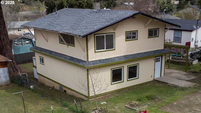 rear view of property with roof with shingles and a chimney