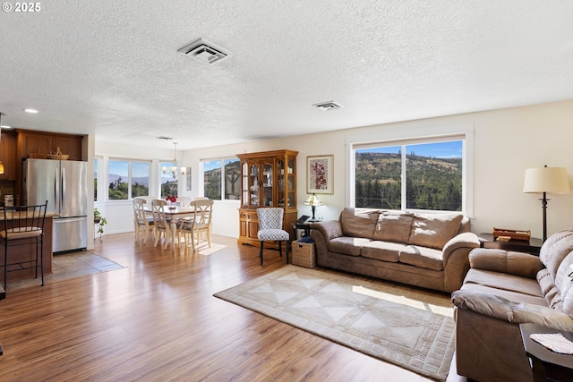 5073 Chenoweth Rd, The Dalles, OR 97058 - living room with light wood finished floors, a textured ceiling, a chandelier, and recessed lighting