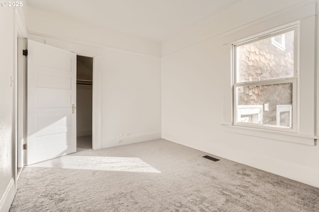 unfurnished bedroom with light colored carpet and a closet