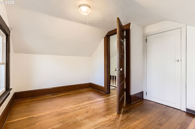 bonus room with lofted ceiling and dark wood-type flooring