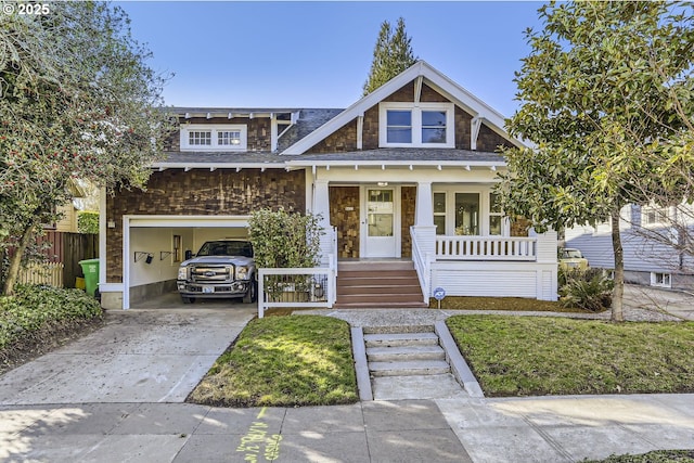 view of front of home featuring a porch, a garage, and a front lawn