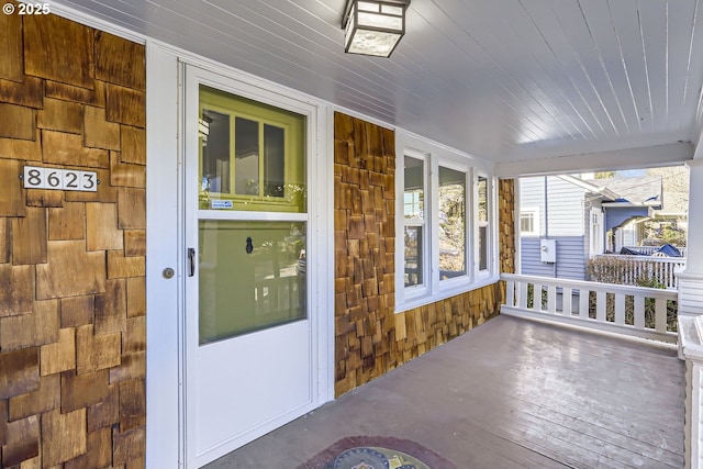 view of exterior entry featuring covered porch