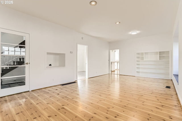 unfurnished living room featuring a wealth of natural light and light wood-type flooring