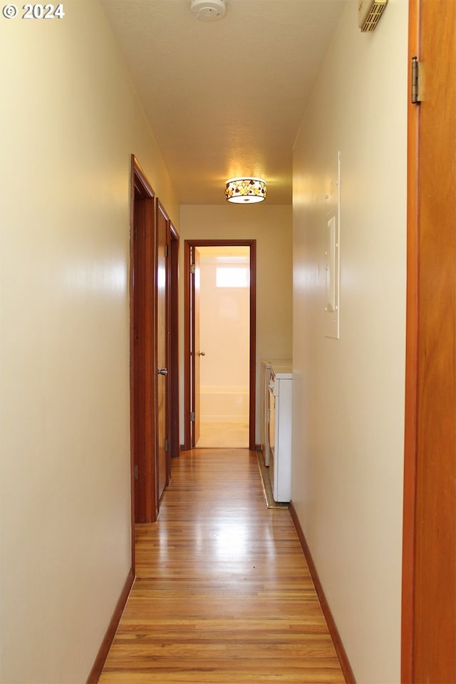 hallway featuring light wood-type flooring and baseboards