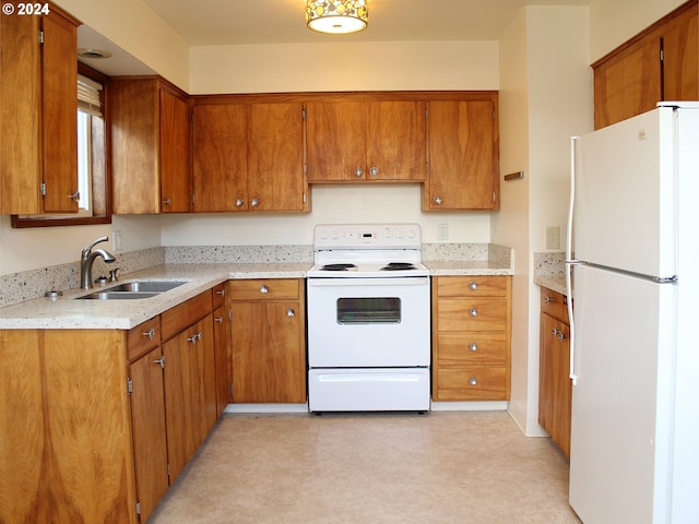 kitchen with white appliances, a sink, brown cabinets, and light flooring