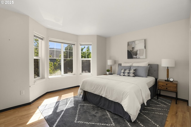 bedroom featuring wood finished floors and baseboards
