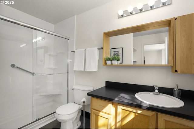 full bath with a stall shower, vanity, and toilet