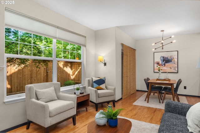 living room with a chandelier, wood finished floors, and baseboards