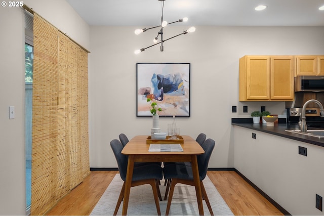 dining area featuring light wood finished floors, a chandelier, recessed lighting, and baseboards