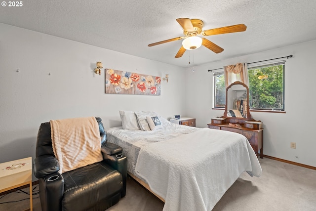 carpeted bedroom with a textured ceiling, baseboards, and a ceiling fan