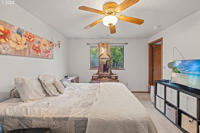bedroom with a ceiling fan, light carpet, and a textured ceiling