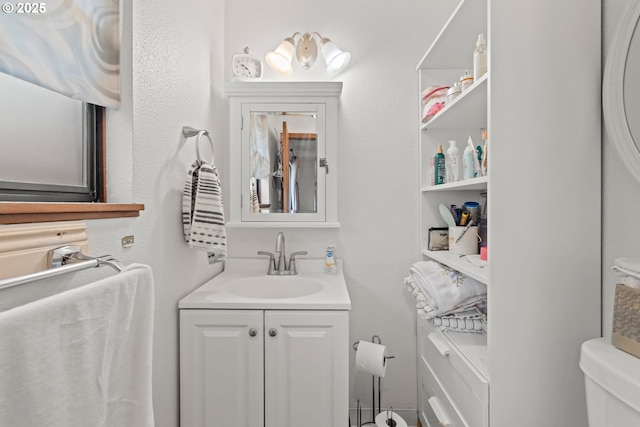 half bath featuring vanity and toilet