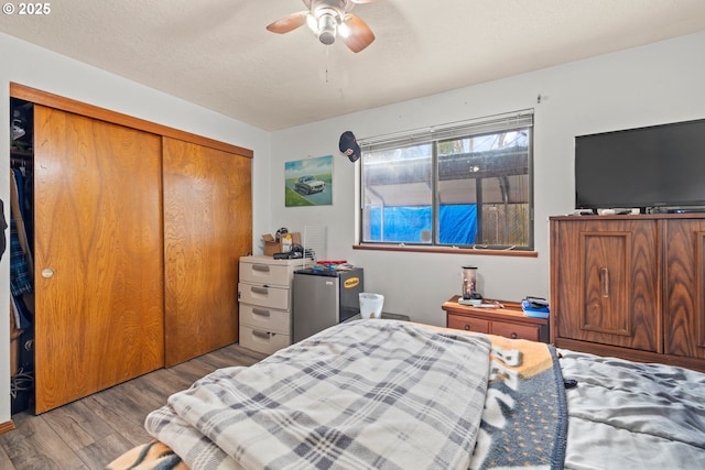 bedroom featuring wood finished floors, a closet, and a ceiling fan