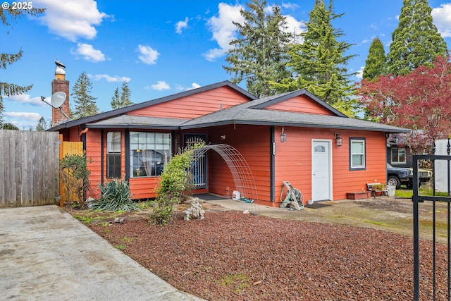 view of front of house featuring fence and roof with shingles
