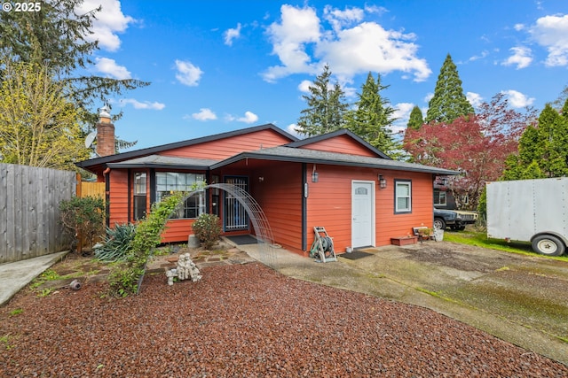 exterior space featuring a chimney and fence