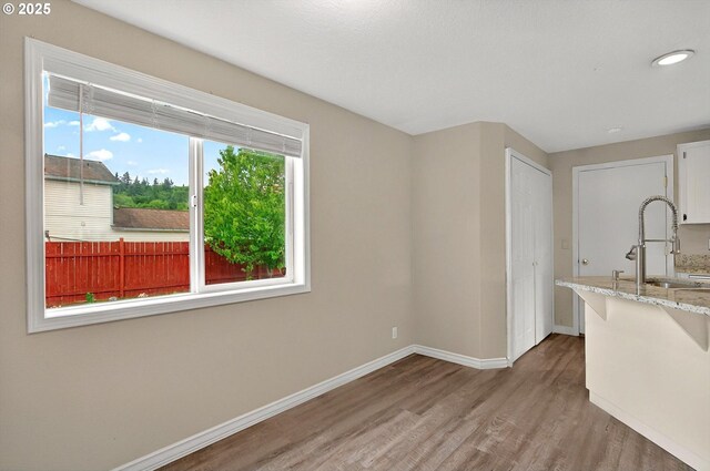 110 Wilshire Way, Kelso, WA 98626 - kitchen with a sink, wood finished floors, baseboards, and light stone countertops