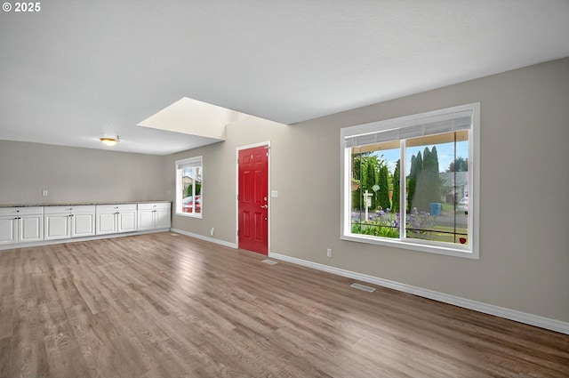 110 Wilshire Way, Kelso, WA 98626 - unfurnished living room with light wood finished floors, baseboards, and healthy amount of natural light