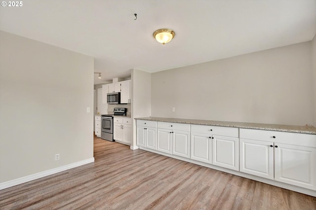 110 Wilshire Way, Kelso, WA 98626 - kitchen with appliances with stainless steel finishes, light wood-type flooring, white cabinetry, and baseboards