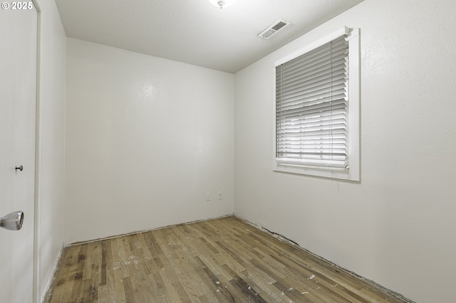 empty room with visible vents and wood finished floors