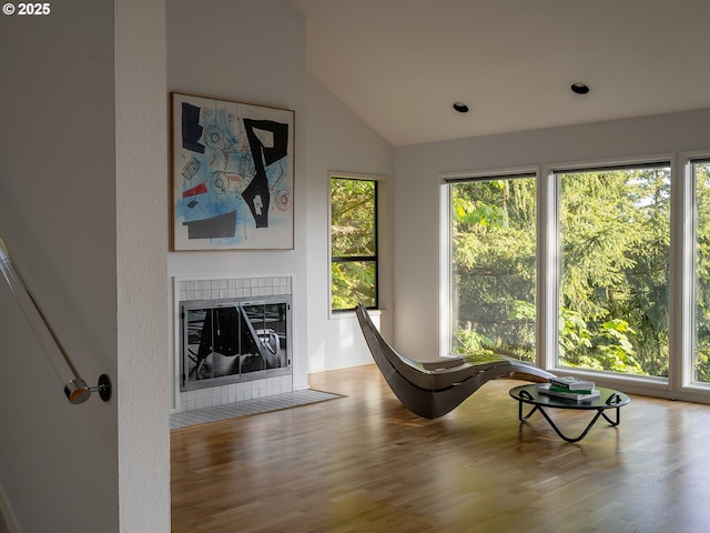 3342 SW Fairmount Blvd, Portland, OR 97239 - living area featuring wood finished floors, lofted ceiling, a tiled fireplace, and recessed lighting