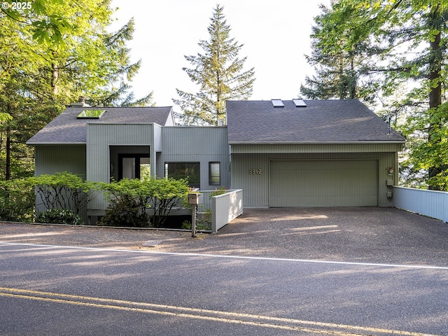 3342 SW Fairmount Blvd, Portland, OR 97239 - view of front of house featuring a shingled roof, a garage, and driveway