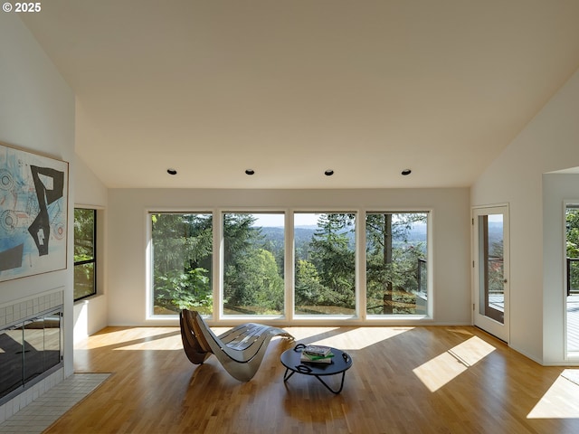 3342 SW Fairmount Blvd, Portland, OR 97239 - living area with lofted ceiling, plenty of natural light, light wood-type flooring, a tiled fireplace, and recessed lighting
