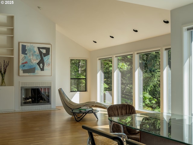 3342 SW Fairmount Blvd, Portland, OR 97239 - living area featuring lofted ceiling, wood finished floors, a tiled fireplace, and recessed lighting