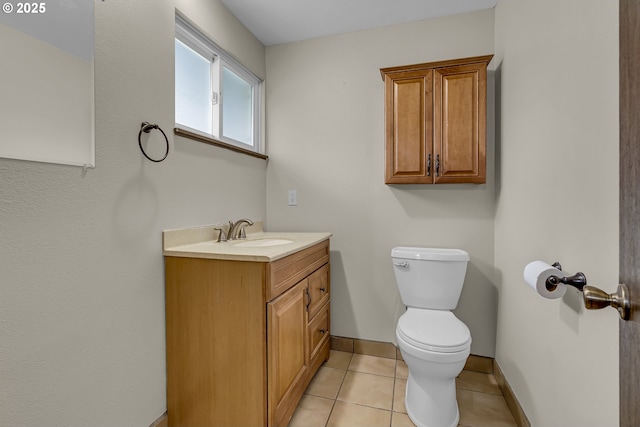 half bath featuring toilet, tile patterned floors, baseboards, and vanity