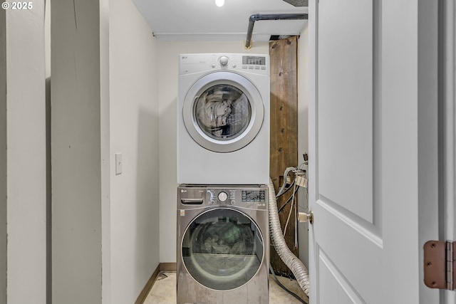 laundry room with stacked washer and clothes dryer, baseboards, and laundry area