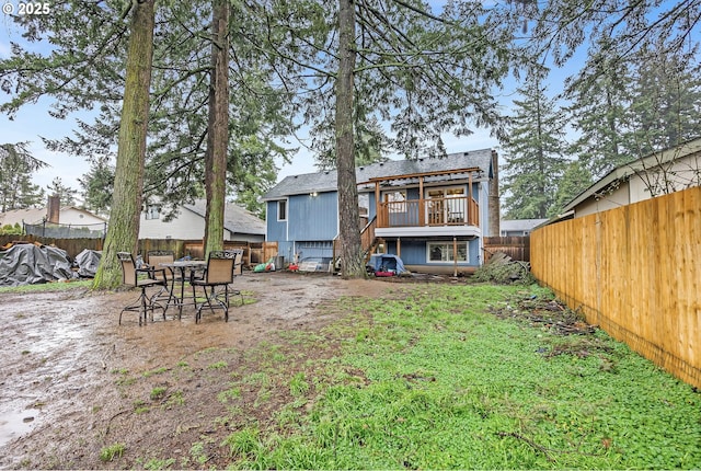 rear view of house featuring a fenced backyard