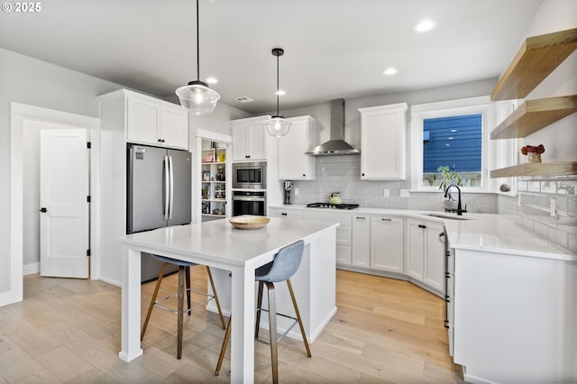 3588 Nestucca Loop, Eugene, OR 97408 - kitchen with stainless steel appliances, wall chimney range hood, a kitchen breakfast bar, open shelves, and light wood-style flooring