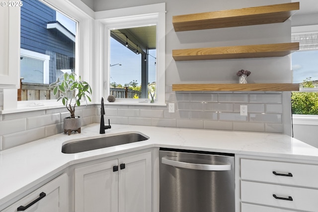 3588 Nestucca Loop, Eugene, OR 97408 - kitchen with stainless steel dishwasher, open shelves, white cabinetry, tasteful backsplash, and light stone countertops