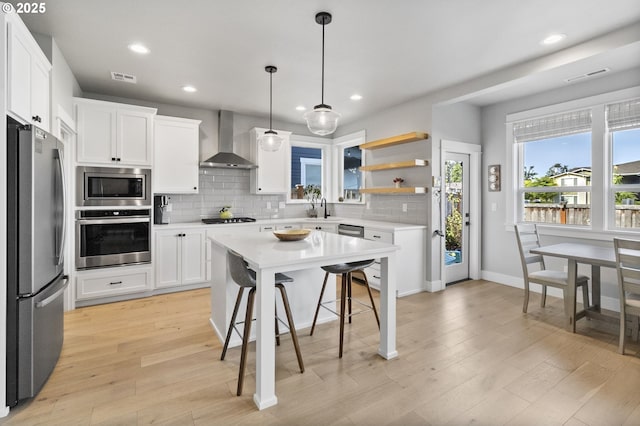 3588 Nestucca Loop, Eugene, OR 97408 - kitchen with stainless steel appliances, wall chimney range hood, recessed lighting, light countertops, and backsplash