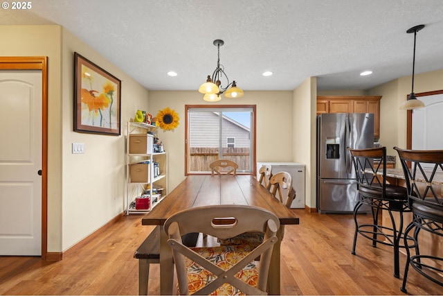 dining space with light wood-style floors, baseboards, a textured ceiling, and recessed lighting