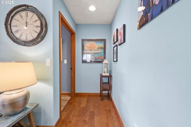 hallway featuring baseboards and wood finished floors