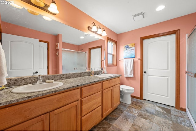 full bathroom with double vanity, a sink, visible vents, and a shower stall