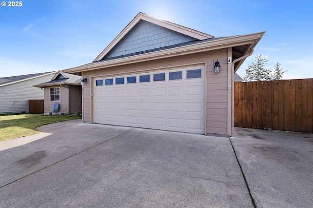 view of front of house featuring a garage, concrete driveway, and fence