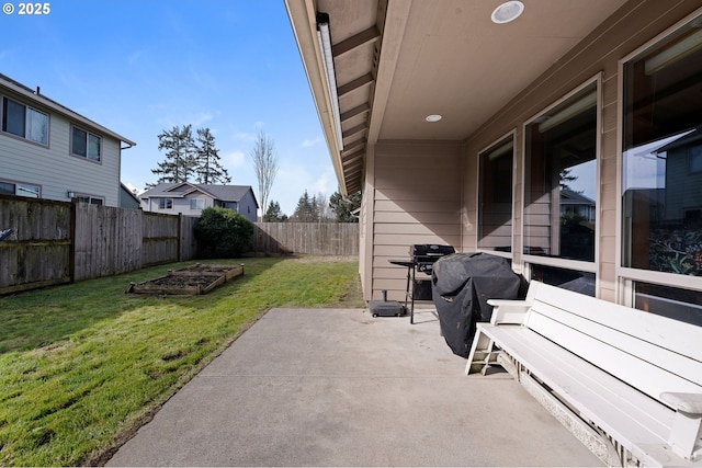 view of patio featuring a fenced backyard, a garden, and a grill