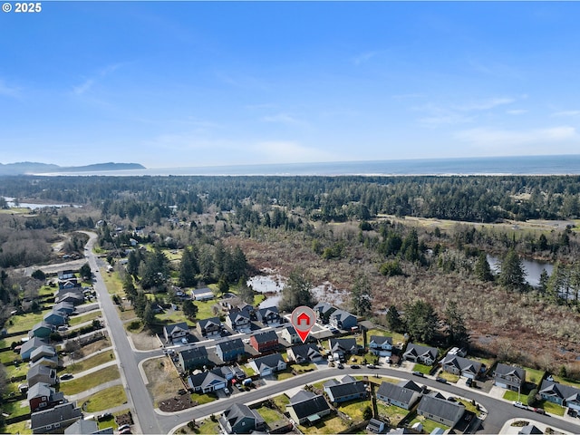 aerial view with a water view and a wooded view